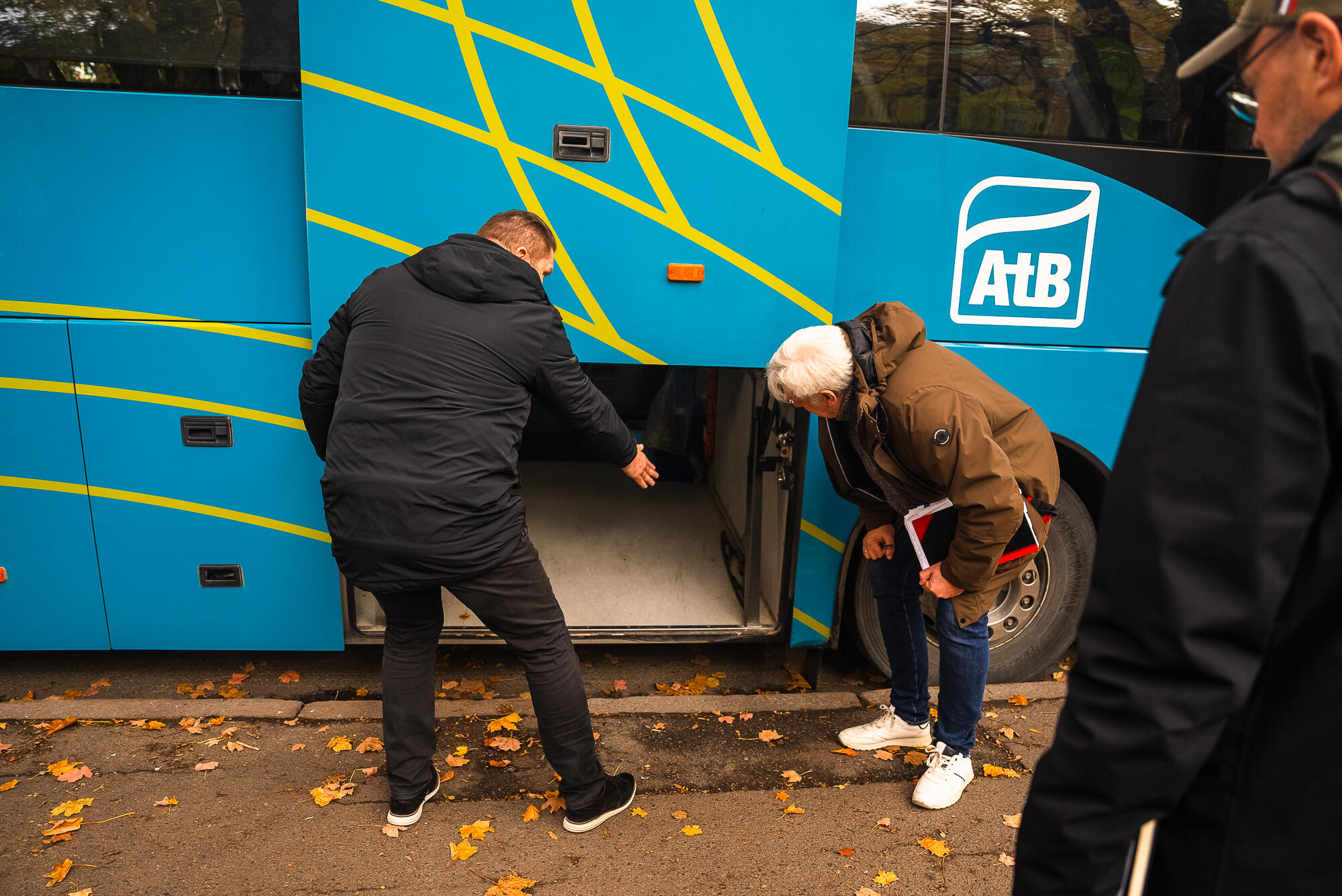 To menn inspiserer bagasjerom på regionbuss