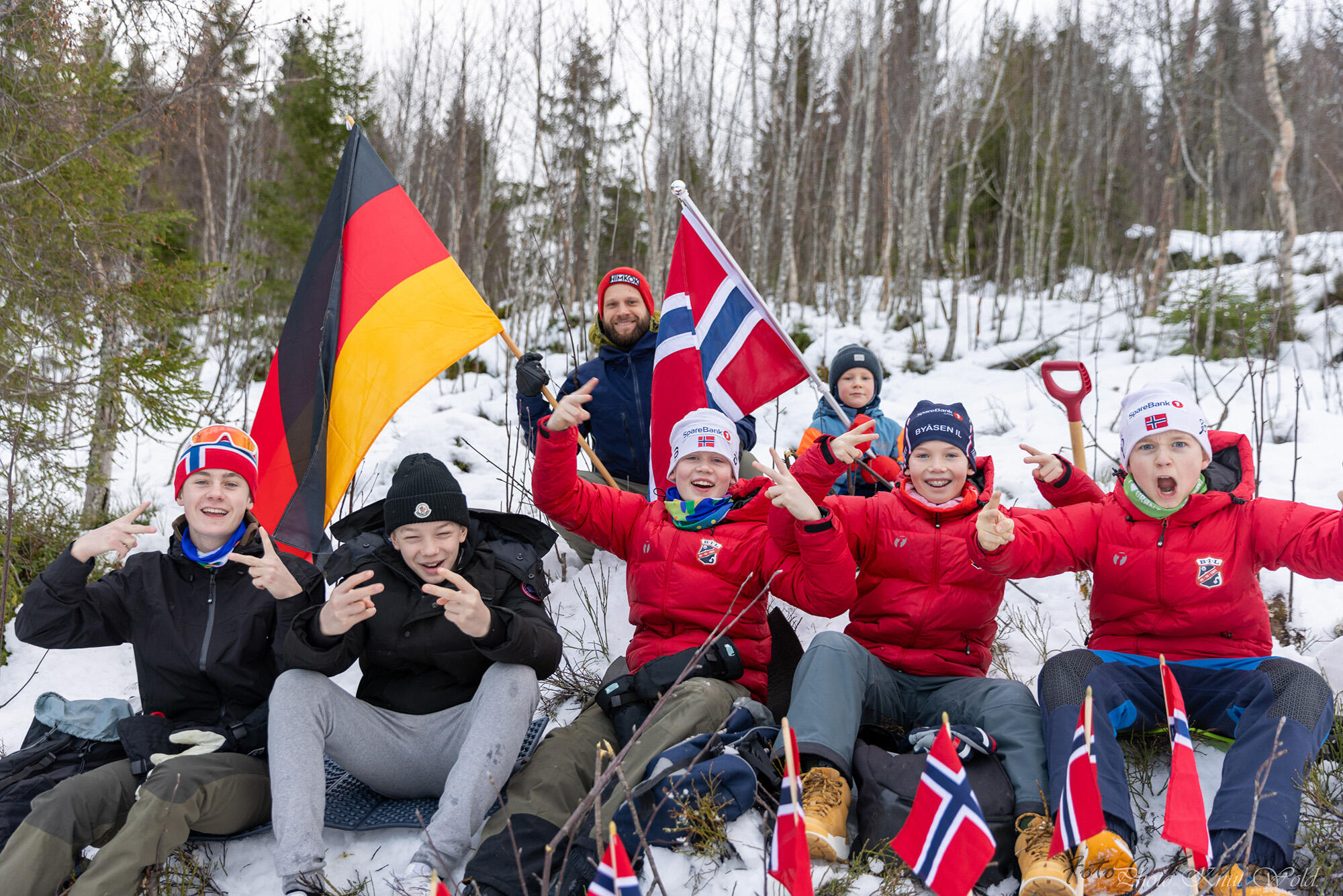 Fem barn og en voksen poserer for kamera i skogen